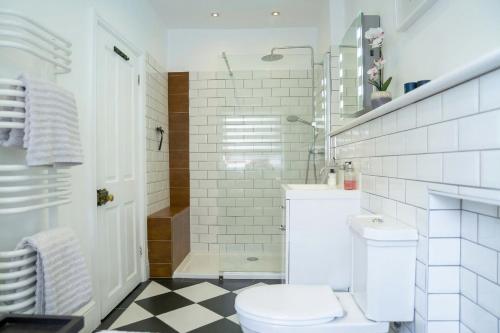 a white bathroom with a toilet and a shower at Sunny Homestay Room, 10 Mins North Laine, 6 Mins Station in Brighton & Hove