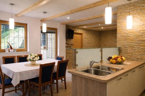 a kitchen with a sink and a table with chairs at Hiša Lunna - Apartments in a Forest Paradise in Vitanje