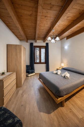 a bedroom with a large bed and wooden ceilings at Ginepro Home Holidays in Villanova Monteleone
