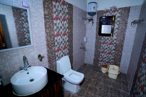 a bathroom with a white toilet and a sink at Himalayanblues cottages&stays in Mukteshwar
