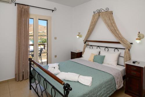 a bedroom with a large bed and a balcony at Villa Andromeda in Amorgos
