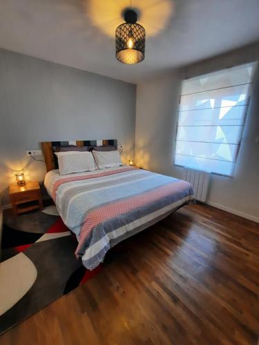 a bedroom with a bed and a window at La Grange de Lilou in Aiffres