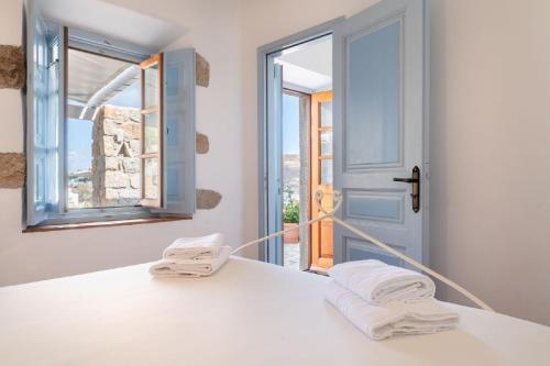 a room with a bed with towels and a window at Theologos Houses in Grikos