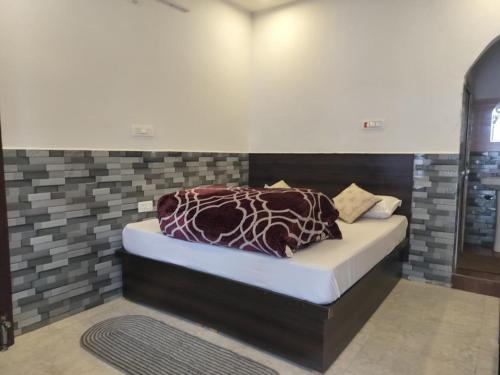 a bedroom with a bed in a room at Hotel Shri Yamuna Gaulok Dham in Kharsālī
