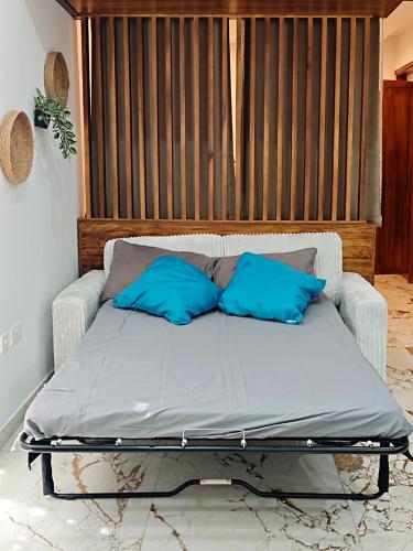 a bed with two blue pillows on top of it at Charming Studio in Historic Kalkara Malta in Kalkara