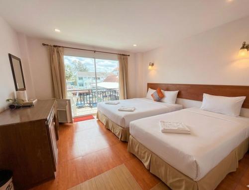 a hotel room with two beds and a window at Hi2 Cha-Am in Cha Am
