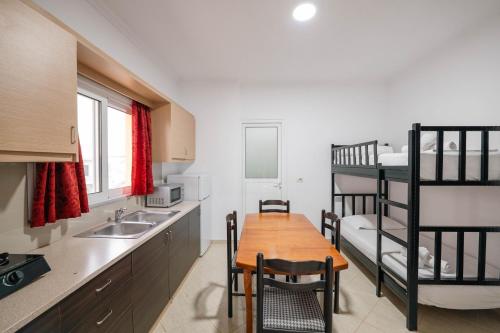a kitchen with a table and a bunk bed at Vila Myrtaj in Ksamil