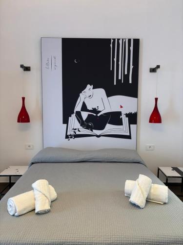 a bed with a picture of a woman sitting on a chair at Camere a Sud in Alliste
