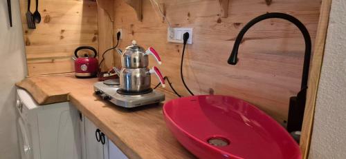 a kitchen counter with a red sink and a mixer at Kelebek Ayvalık in Ayvalık