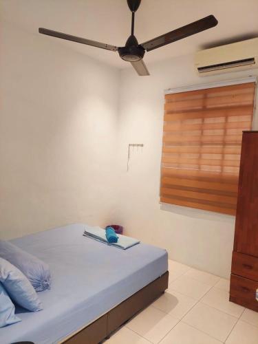 a bedroom with a bed with a ceiling fan at Abadi Homestay Ipoh in Ipoh