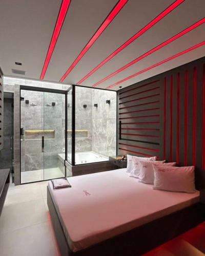 a bedroom with a large bed and a bath tub at Motel Queens Aeroporto de Congonhas in São Paulo