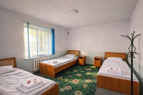 a room with two beds and a window at Sunny Hostel in Osh