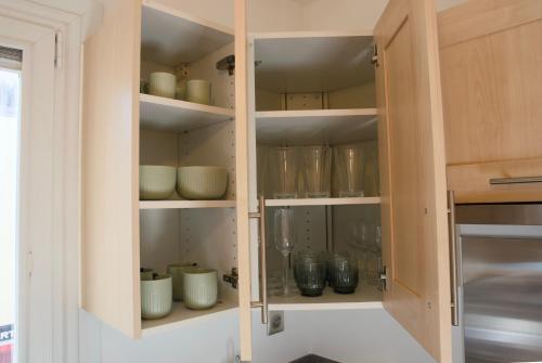 a cupboard filled with bowls and vases at Chez Leela in Poissy