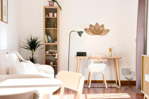 a living room with white furniture and a table and chairs at Chez Leela in Poissy