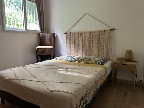 a bedroom with a bed and a chair and a window at Villa Coco Caraïbes in Deshaies