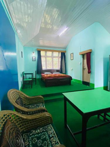 a bedroom with a bed and a table and chairs at Kalimpong Heritage Homestay in Kalimpong