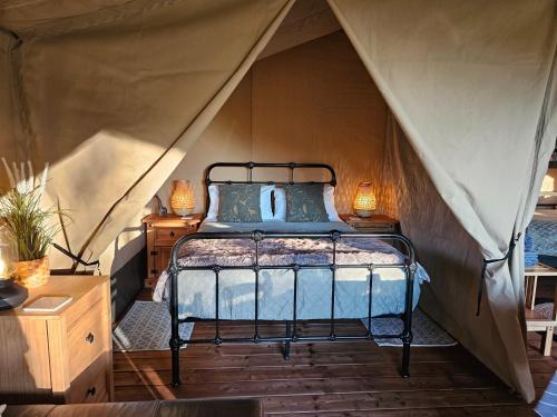 a bedroom with a bed in a tent at Le Ranch Camping et Glamping in Madranges