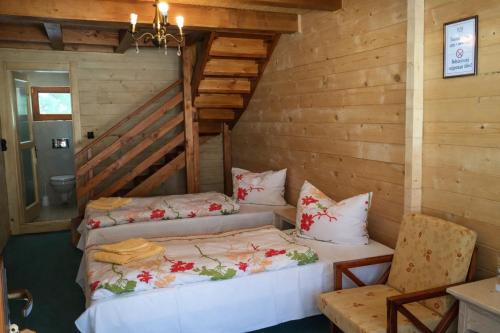 a room with two beds and a chair in it at Lacu Roșu Escape Lodge in Lacu Rosu