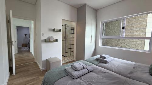 a bedroom with a bed with towels on it at NamibStay Swakop Self Catering in Swakopmund