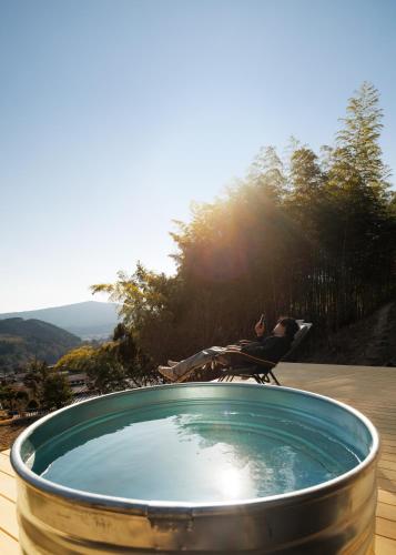 a person sitting in a chair next to a hot tub at OKANiWA 丘庭 in Nagiso