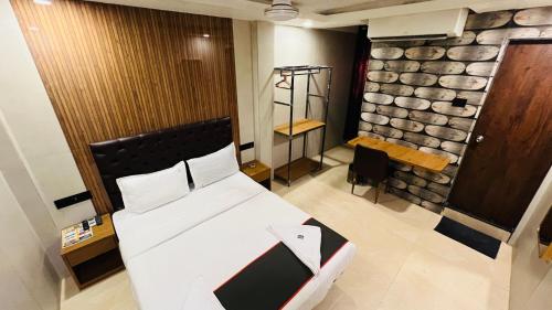 a bedroom with a bed and a stone wall at U LIFE HOTEL in Mumbai