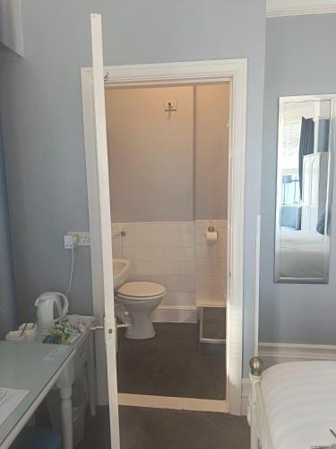 a bathroom with a toilet and a sink at Audley Guest House in Llandudno