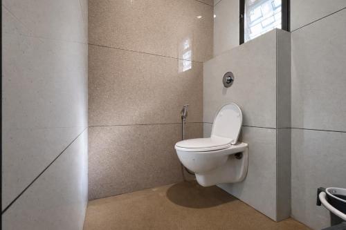 a bathroom with a toilet and a window at U LIFE HOTEL in Mumbai