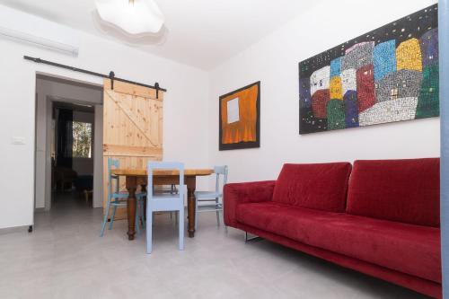 a living room with a red couch and a table at Casa Brezza Marina in Punta Marina