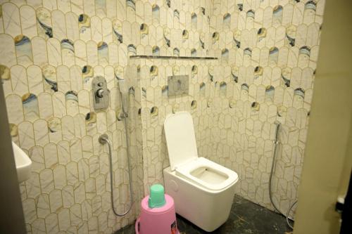 a bathroom with a toilet and a tiled wall at hotel nemi residency jagdalpur in Jagdalpur