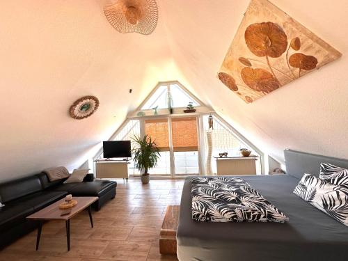 a living room with a black couch and a window at Appartement Bali in Hüllhorst