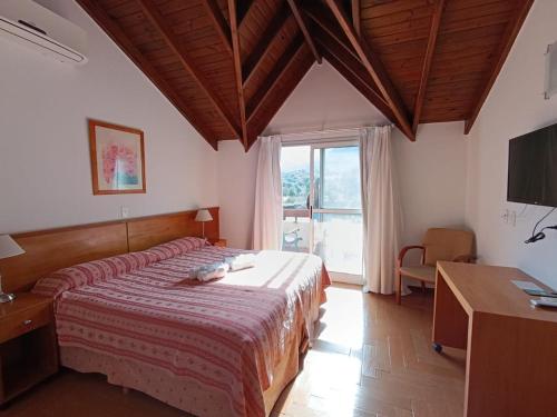 a bedroom with a bed and a desk and a window at Rincon del Valle in Merlo