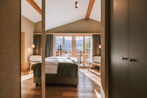 a bedroom with a bed and a large window at Hotel Fiescherblick in Grindelwald