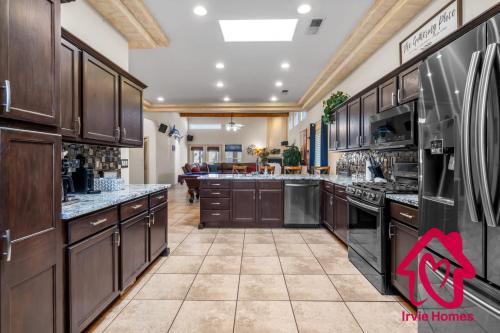 a large kitchen with wooden cabinets and appliances at Desert Hills - An Irvie Home in Albuquerque