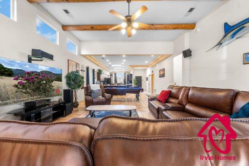 a living room with leather furniture and a ceiling fan at Desert Hills - An Irvie Home in Albuquerque