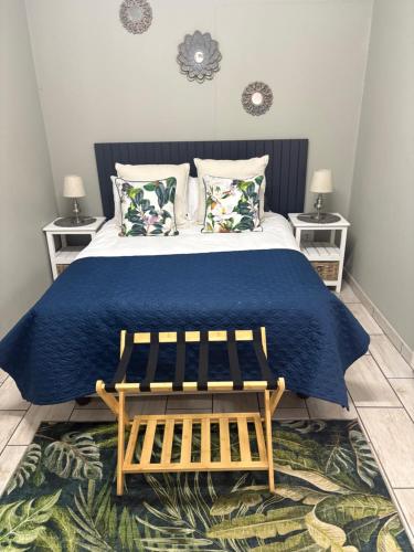 a bedroom with a large bed with a blue blanket at Happy Daze Spacious 45m2 Self Catering Apartment in Swellendam