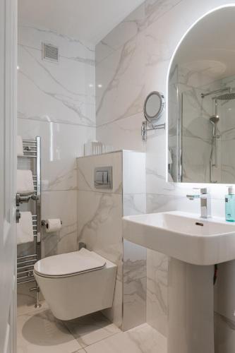 a white bathroom with a sink and a toilet at The Malone Hotel in Belfast