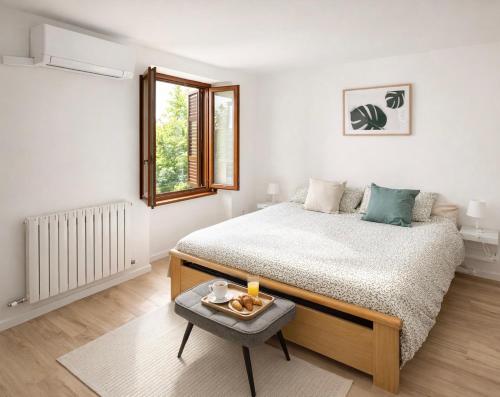 a white bedroom with a bed and a table at Apartment Cà Dai Noni - Family & Pet Friendly - Terrace - Near Lake Maggiore in Feriolo