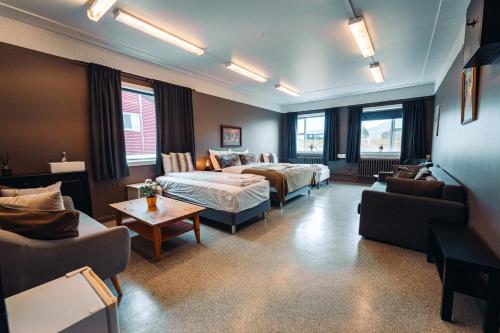 a hotel room with a bed and a couch and a table at Ljosafoss Lake Guest House in Selfoss