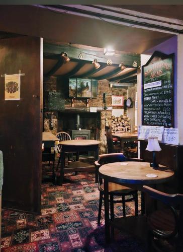a restaurant with tables and chairs and a menu on the wall at The Northmore Arms in Throwleigh