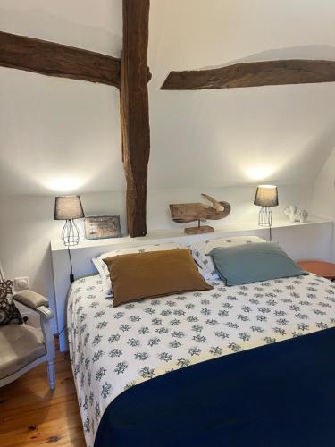 a bedroom with a bed and two lamps on the wall at La Gruchette in Gruchet-Saint-Siméon