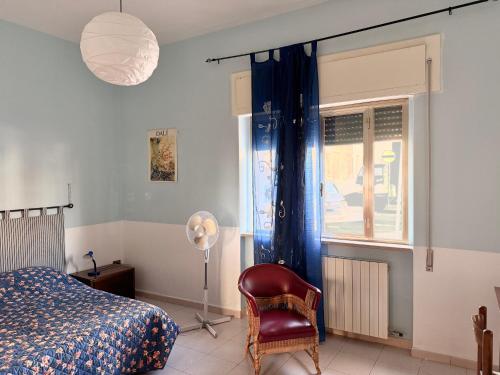 a bedroom with a bed and a chair and a window at Il Barbagianni in Chieuti