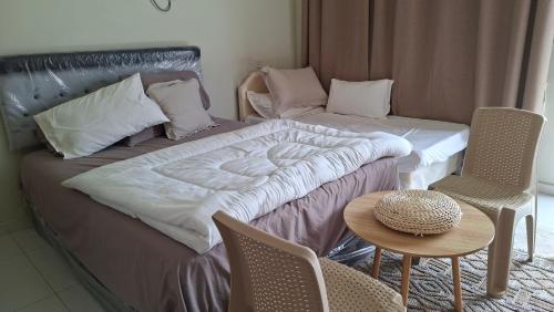 a bedroom with a bed and a table and chairs at شاليهات رمال بديه in Al Raka