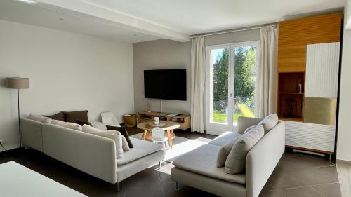 a living room with two couches and a flat screen tv at Rivéa Bizy - Villa 150m2 - 2ou5 CH - 2 SDB - Parking Wifi in Vernon