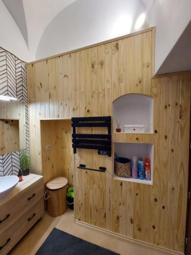 a bathroom with a wooden wall with a sink at La bóveda in Zafra