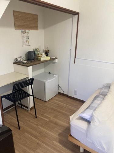 a room with a bed and a desk and a chair at Vivi House in Kyoto