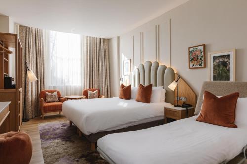 a hotel room with two beds and a chair at The Malone Hotel in Belfast