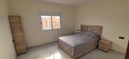 a bedroom with a bed and a window at Appartement 2 chambres in Selouane