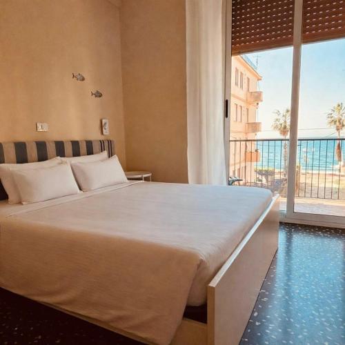 a bedroom with a large bed and a large window at Hotel Elisabetta in Sestri Levante