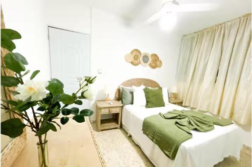 a bedroom with a bed with green sheets and a window at Colonial Zone 2BR Apartment Prime Location in Santo Domingo