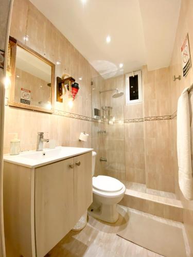 a bathroom with a toilet and a sink and a shower at Colonial Zone 2BR Apartment Prime Location in Santo Domingo